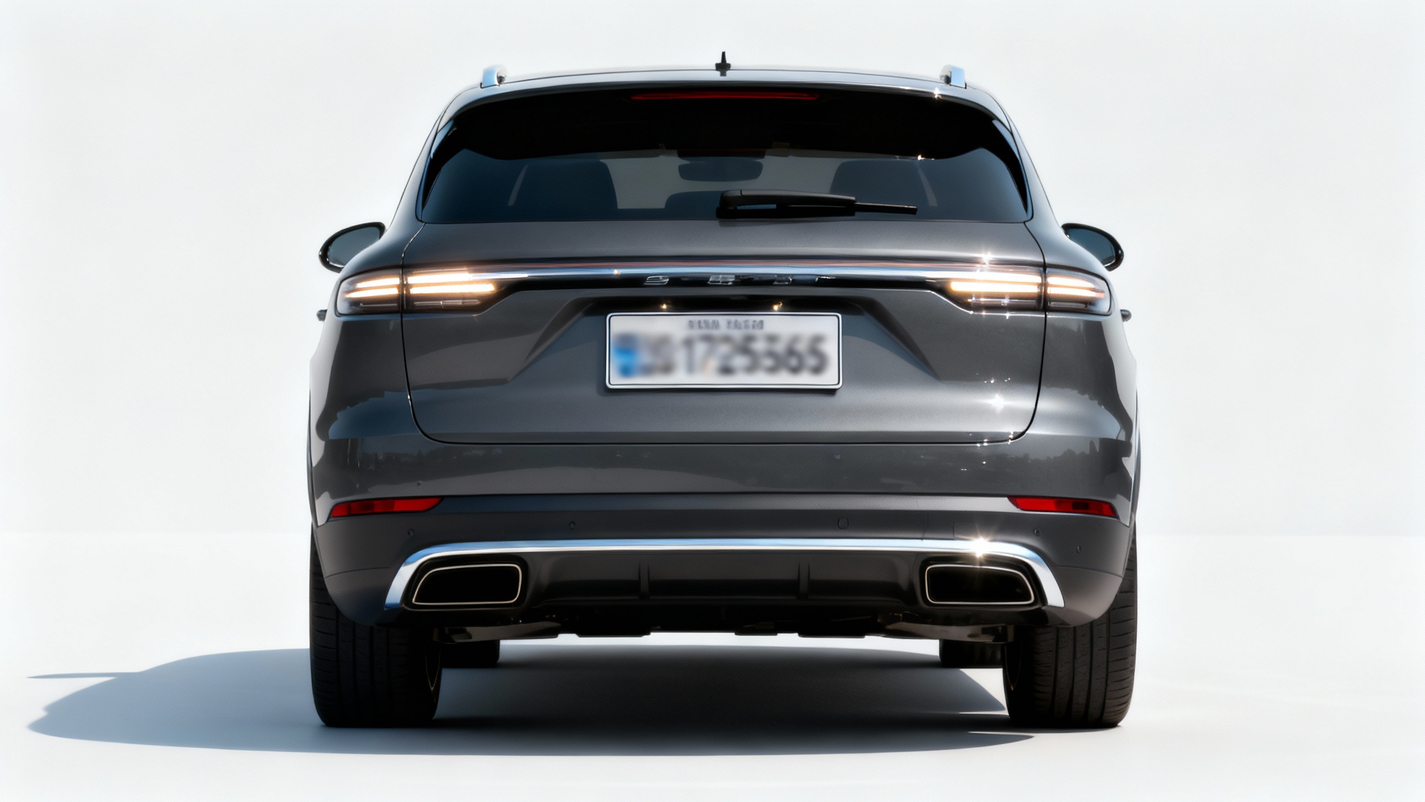 A close-up of the back of a modern grey car on a white background, with the license plate intentionally and completely blurred out for privacy.