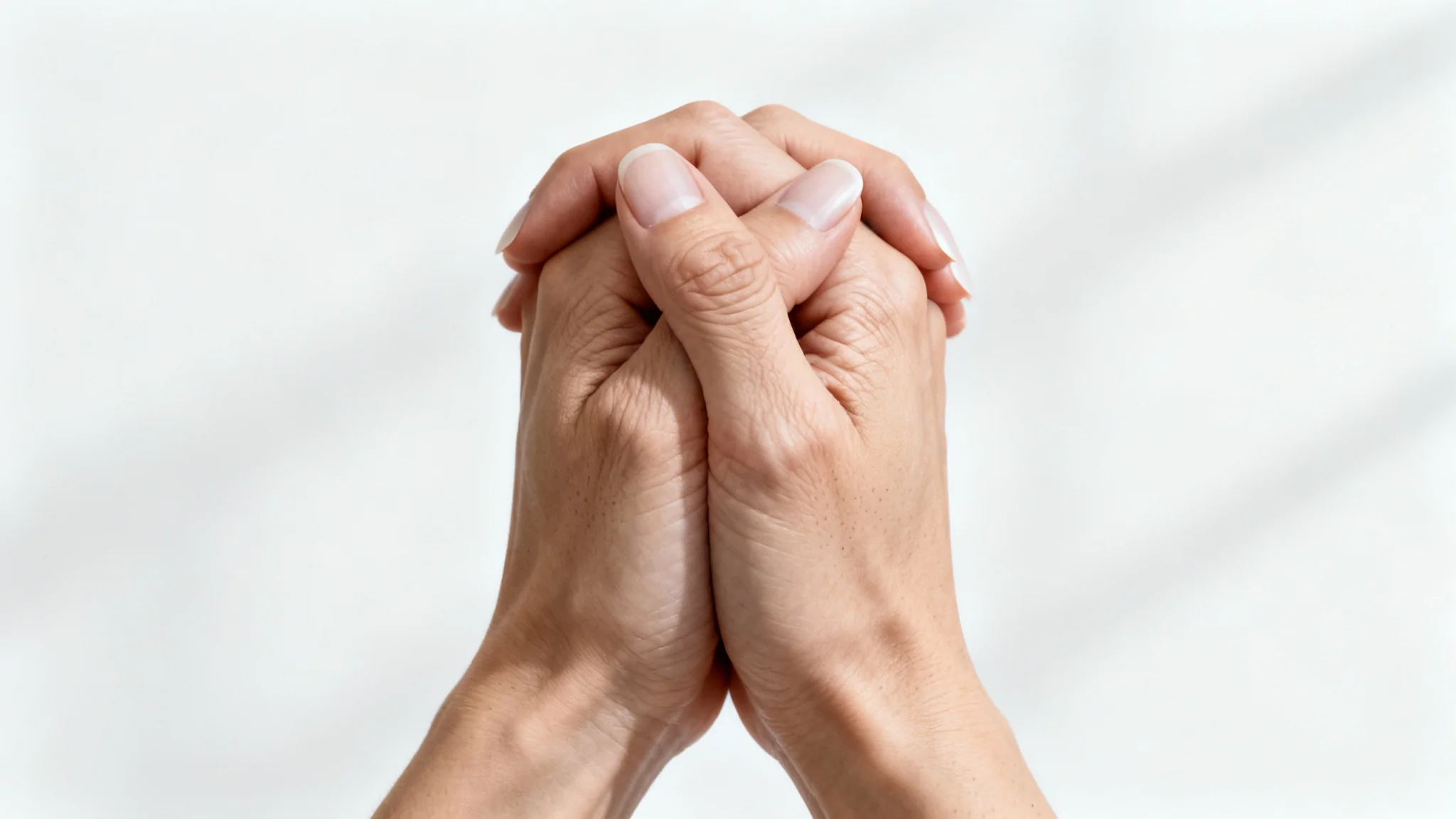 A hyperrealistic image of two anatomically perfect hands gently clasping against a stark white background, showcasing flawless detail and form.