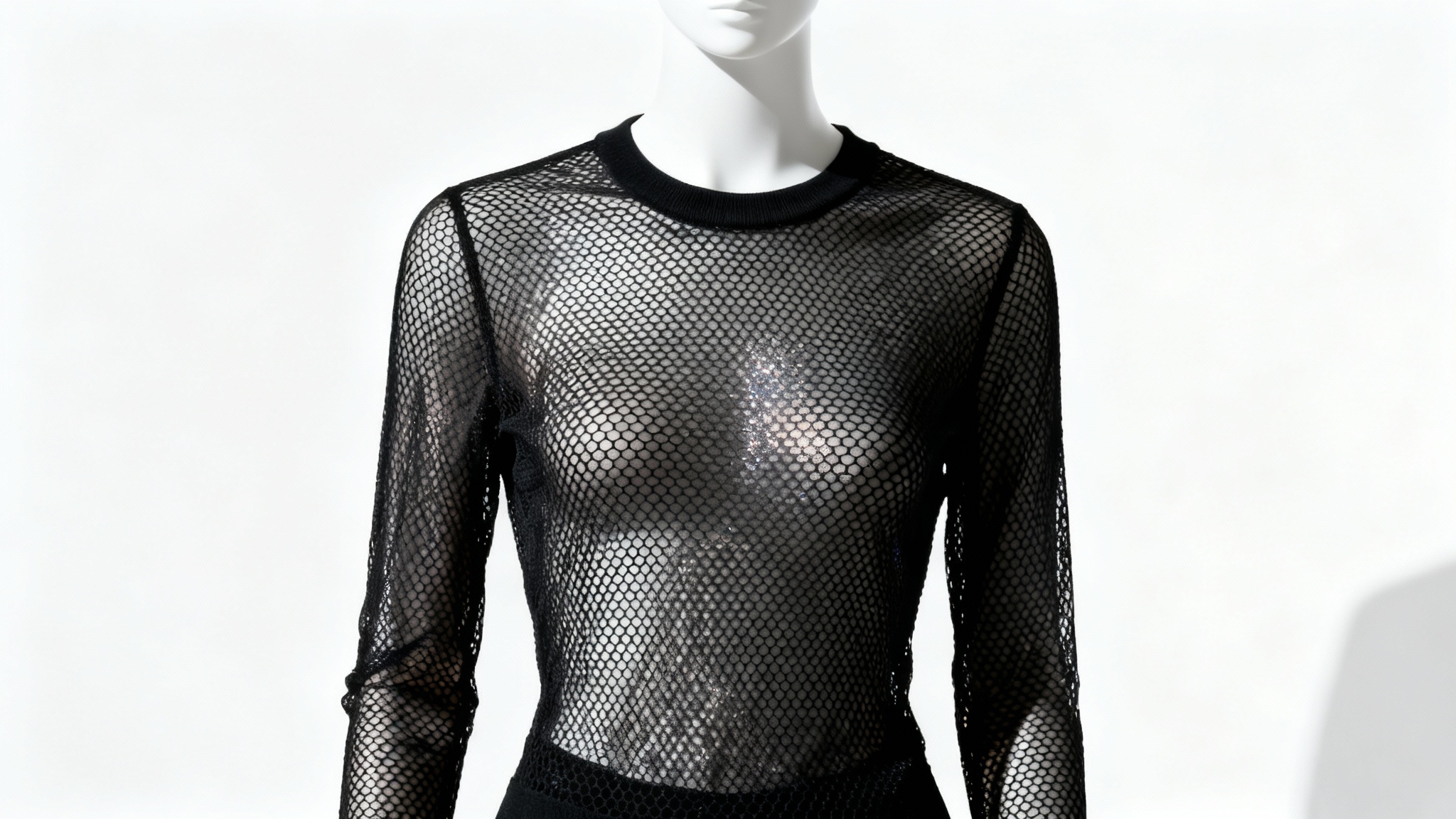 A studio photograph of an elegant, long-sleeved black mesh top with a honeycomb pattern, displayed on a plain white background.