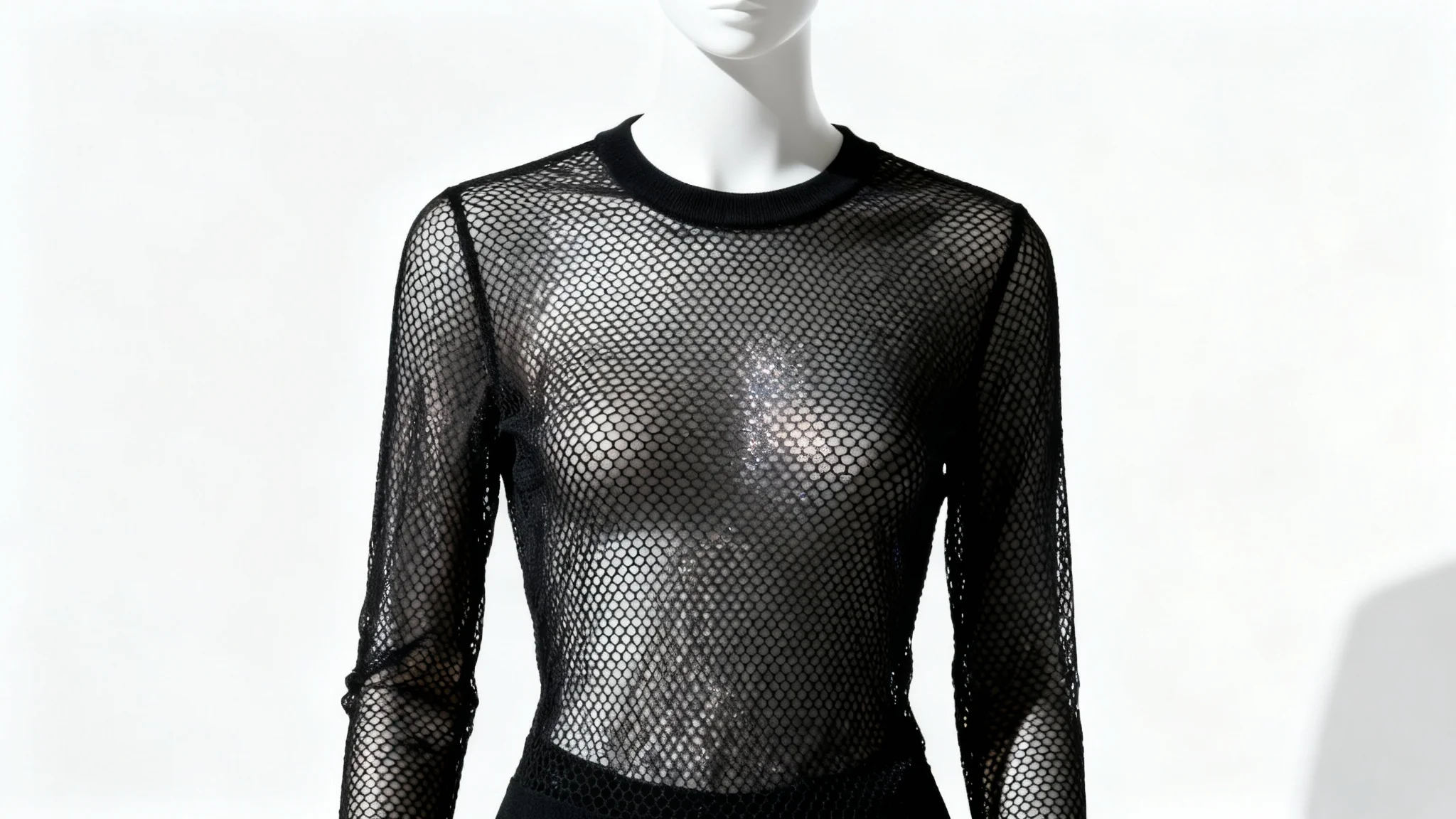 A studio photograph of an elegant, long-sleeved black mesh top with a honeycomb pattern, displayed on a plain white background.