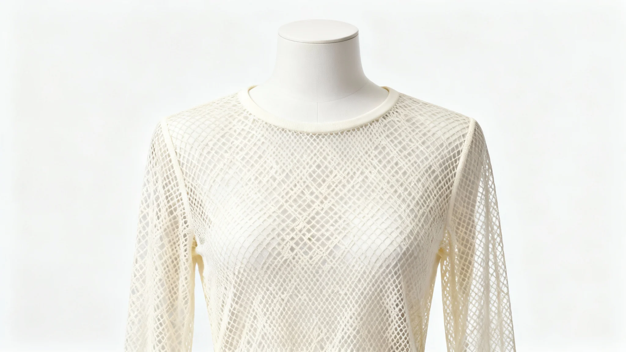 A finely crafted cream-colored long-sleeve mesh top displayed on a white mannequin, showcasing a beautiful sewing pattern result against a white background.