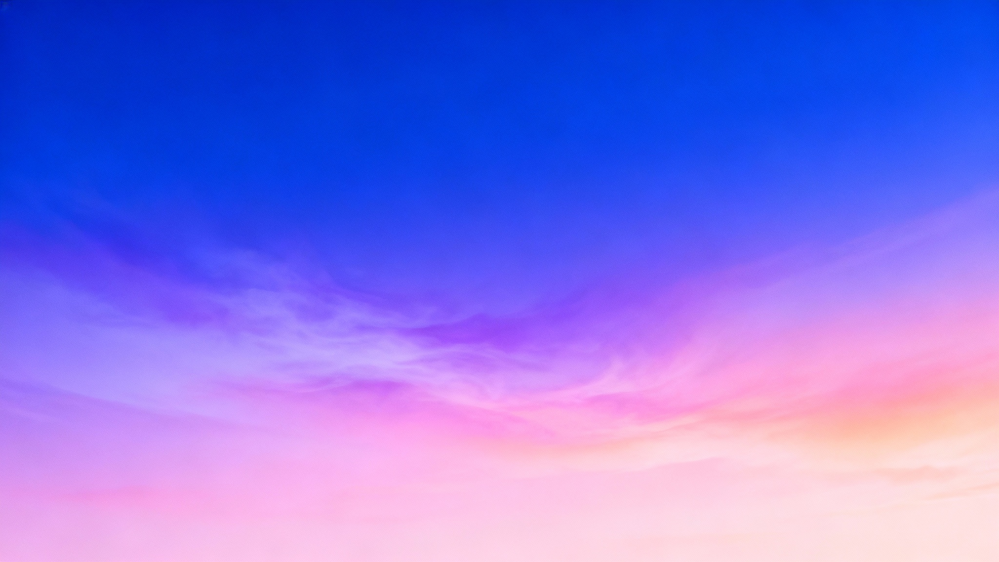 A vibrant abstract gradient background in a 16:9 aspect ratio, transitioning smoothly from a deep royal blue at the top to a light pastel pink at the bottom, with soft hints of lavender and peach.