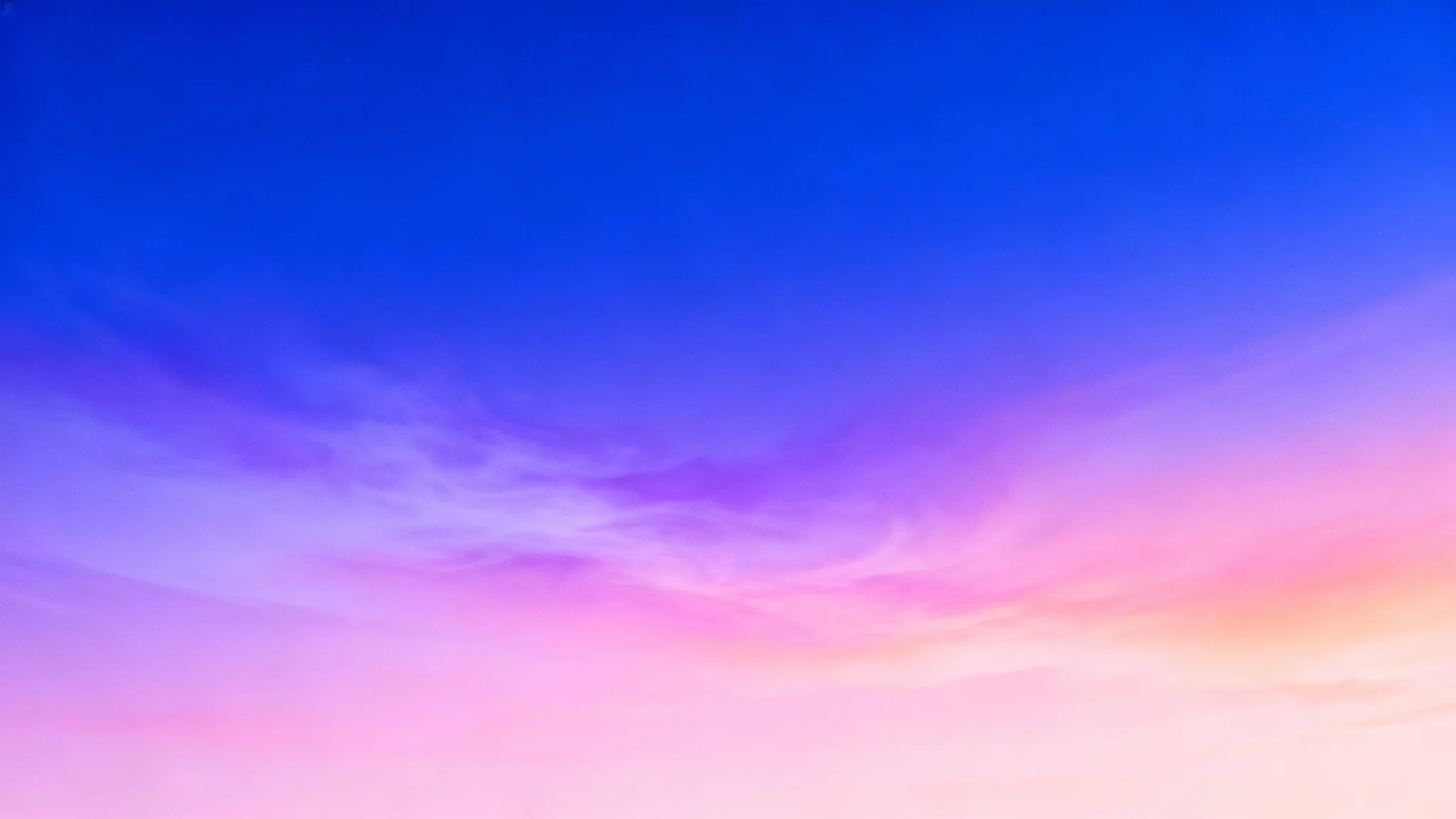 A vibrant abstract gradient background in a 16:9 aspect ratio, transitioning smoothly from a deep royal blue at the top to a light pastel pink at the bottom, with soft hints of lavender and peach.