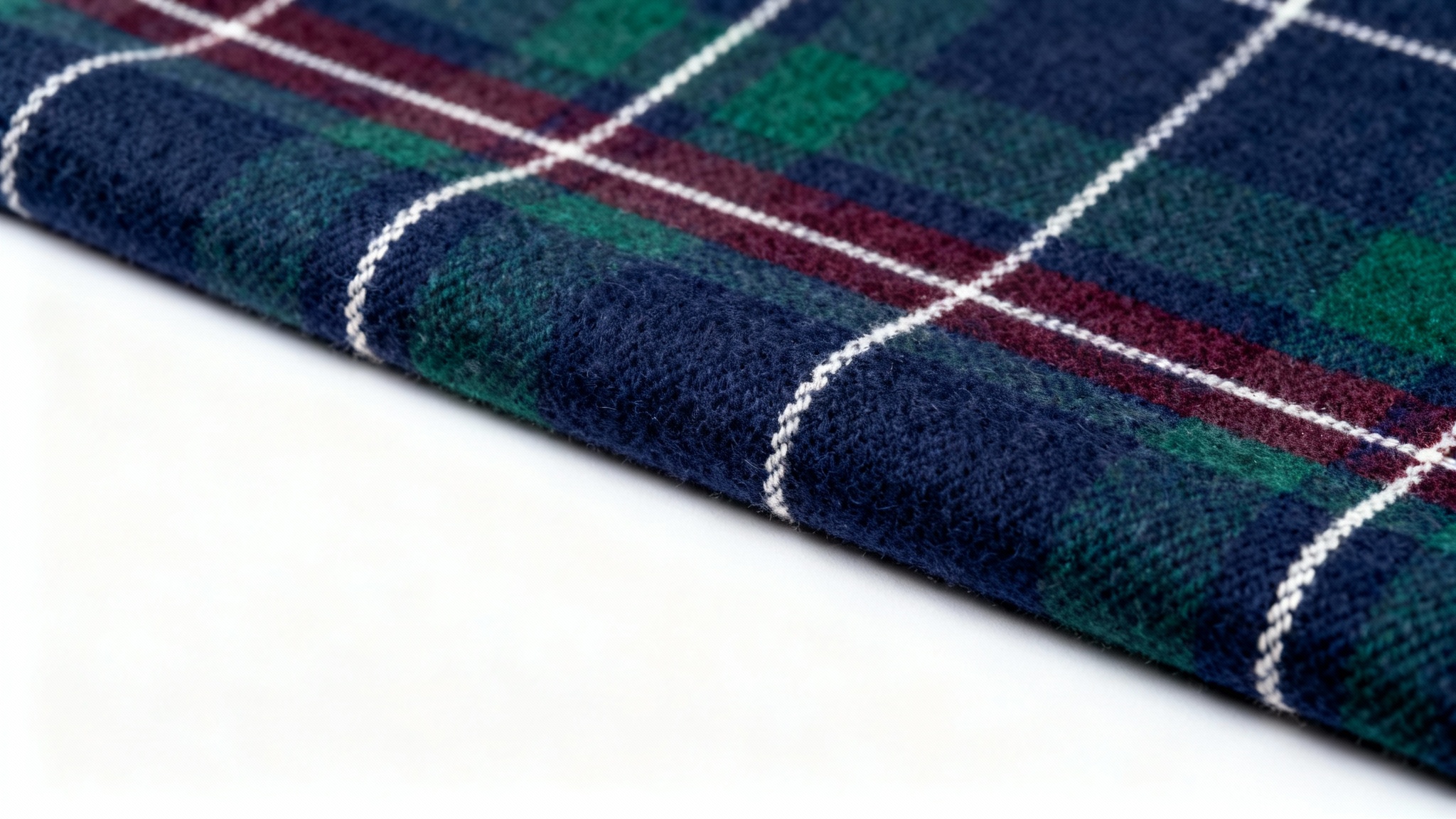 A close-up, detailed photograph of a fabric swatch with a sophisticated plaid pattern in navy, green, and burgundy against a stark white background.