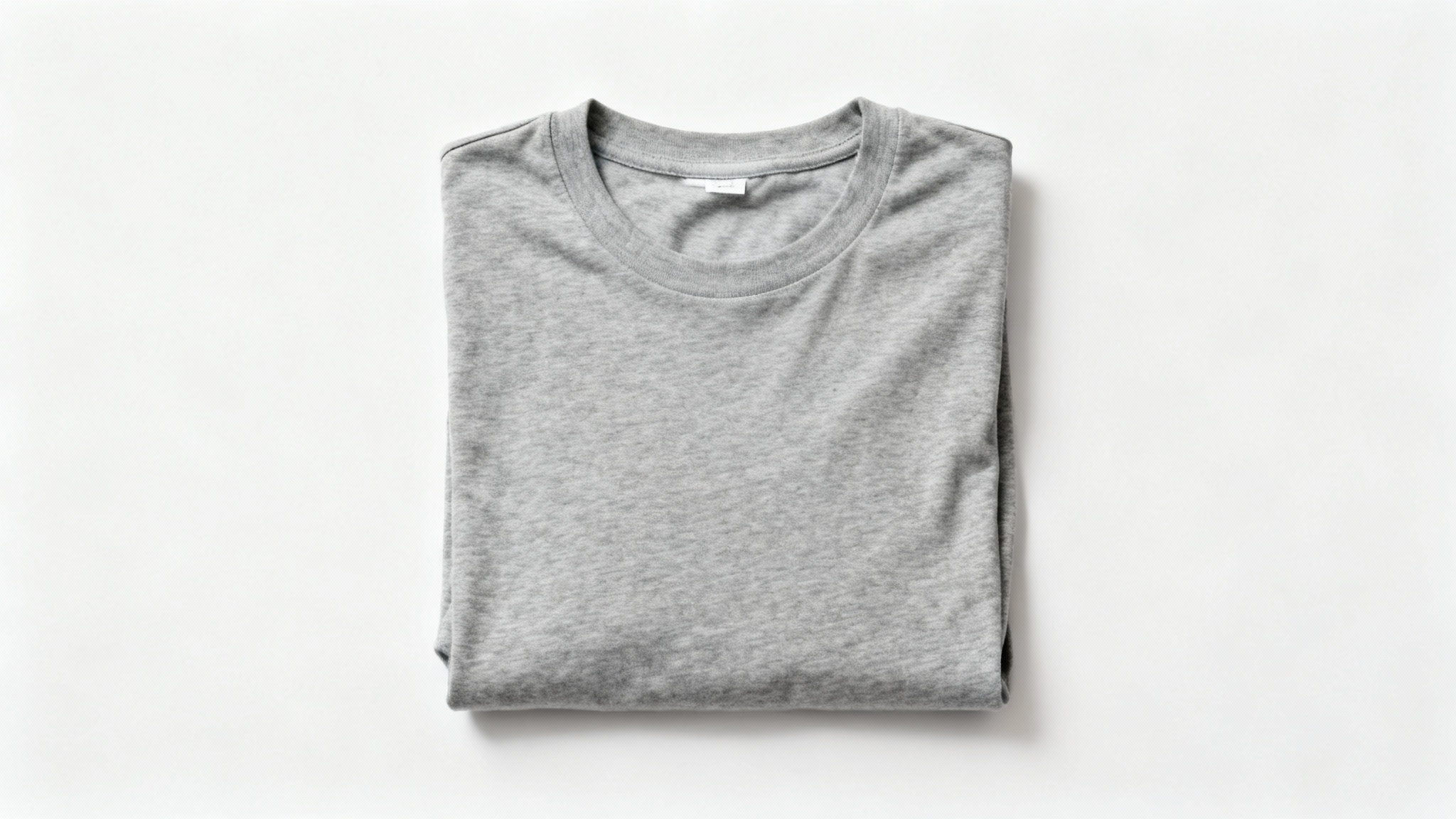 A photorealistic image of a neatly folded gray t-shirt with no logo, displayed on a clean white background, demonstrating the removal of a brand mark.