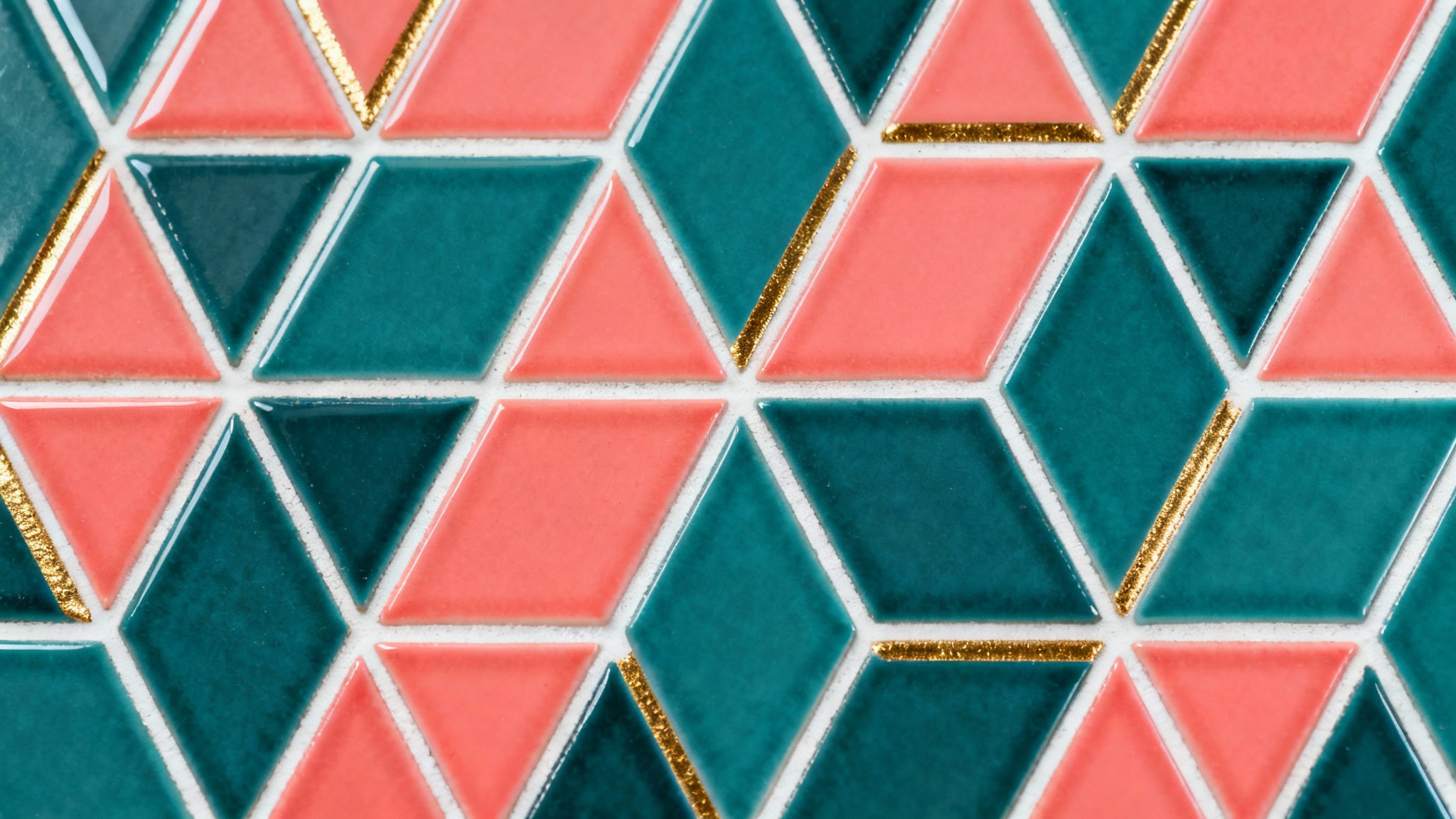 A close-up shot of a modern, seamless tiled background featuring a geometric pattern of teal, coral, and gold hexagons and triangles.
