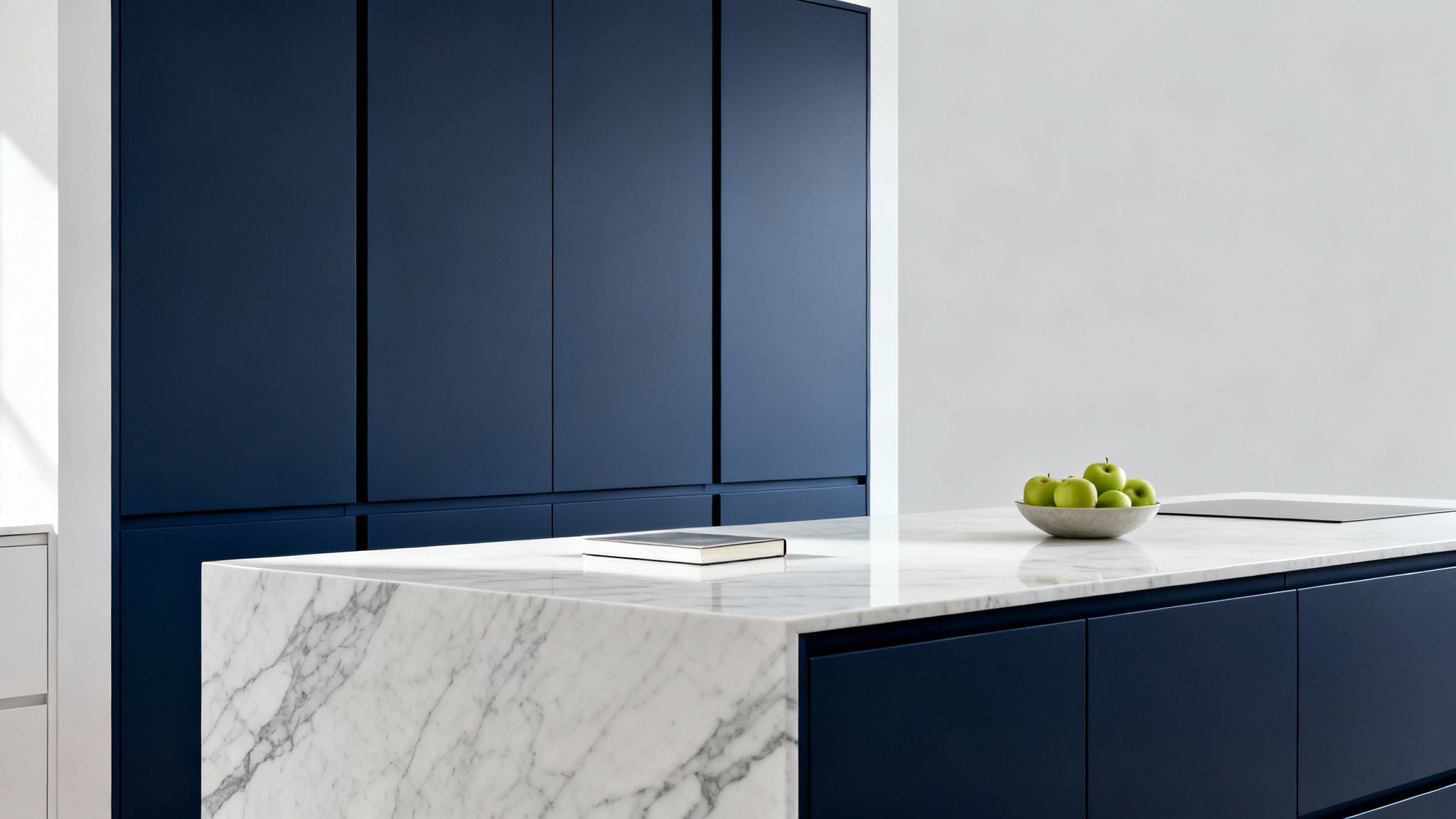 A close-up of a modern kitchen island with matte navy blue cabinets and a white marble countertop, staged for a high-end visualizer.