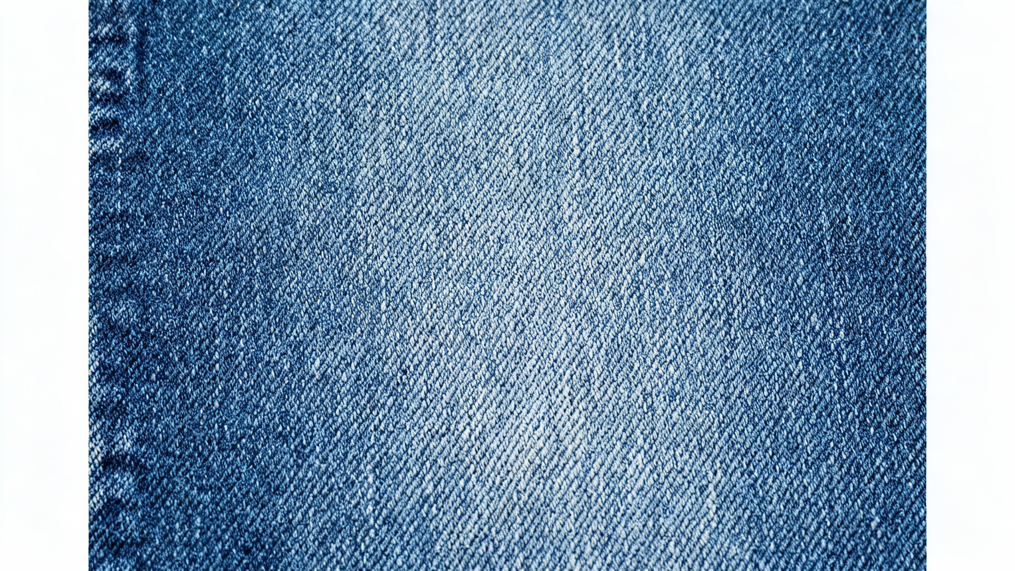 A high-resolution, top-down macro photograph of a seamless blue denim fabric, showcasing its detailed diagonal weave and the texture of its indigo and white threads.